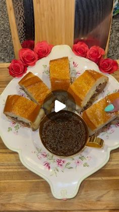 a plate with some food on it next to a cup of coffee and red roses