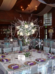 the table is set with silver and purple decorations