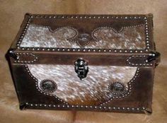 a brown and white box sitting on top of a leather couch with rivets