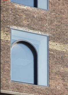 an arched window on the side of a brick building