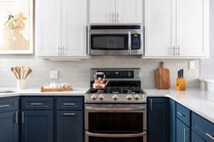 a kitchen with blue cabinets and white counter tops, stainless steel appliances and an oven