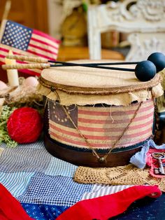 an american flag drum sits on a table next to some other items that are scattered around it