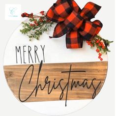 a wooden sign that says merry christmas with a red bow on it and greenery