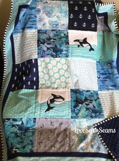 a quilted blanket with dolphins and anchors on it