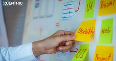 a person placing sticky notes on a bulletin board