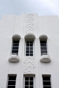 a tall white building with three windows on each side