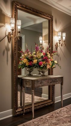 a mirror sitting on top of a wooden table next to a vase filled with flowers