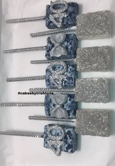 four blue and silver hair clips with sequins on them in a white box