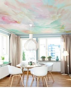 a dining room with painted ceilings and white chairs