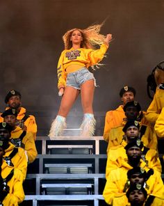 a woman in yellow jacket and shorts on stage