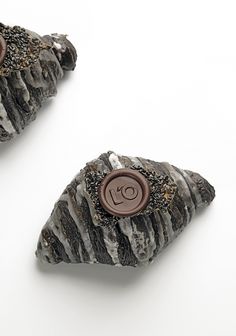 two rocks with buttons on them sitting next to each other in front of a white background