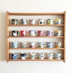 a wooden shelf filled with lots of coffee mugs