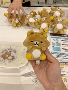 a person holding a teddy bear in front of some other stuffed animals on a table