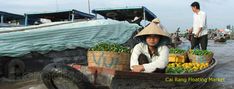 a woman sitting in a boat filled with fruit