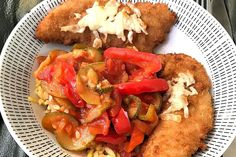 a white plate topped with fried fish and veggies on top of cornbreads