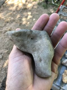 a hand holding a rock shaped like an elephant's head in the palm of someones hand