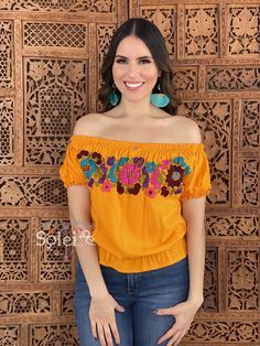 This Beautiful Off the Shoulder Crop Top is the perfect Top for a fun day out or special event. It is comfortable, has elastic around the shoulders, sleeves and waist. This blouse is completely hand embroidered by Mexican Artisans in Chiapas, Mexico making it one of a kind! Note: This blouse comes in one size which fits sizes Small and Medium. Shop the hand painted earrings modeled here: https://www.etsy.com/es/listing/802949597/aretes-artesanales-pintado-a-mano-aretes?ref=listings_manager_grid Orange Embroidered Tops For Summer, Yellow Bohemian Tops With Floral Embroidery, Bohemian Yellow Tops With Floral Embroidery, Orange Bohemian Top With Floral Embroidery, Summer Embroidered Orange Blouse, Embroidered Yellow Tops For Vacation, Orange Embroidered Summer Blouse, Yellow Embroidered Top For Vacation, Summer Orange Embroidered Blouse