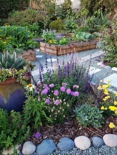 a garden filled with lots of different types of flowers and plants next to each other