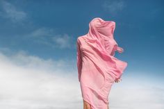 a woman in a pink dress flying through the air