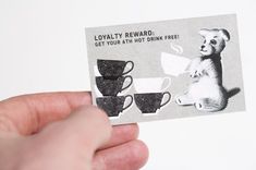 someone is holding up a business card with coffee cups and a koala bear on it