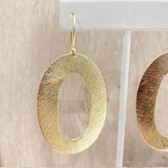 "These handcrafted earrings are modern and chic! Large gold circular hoops measuring over 2 inches long by 1.5 inches wide dangle from matching fish hooks. Earring material is brass dipped in brushed gold and lacquered with a protective varnish to prevent tarnish. Such beautiful texture! The earrings measure approximately 2.75\" in total length. A fabulous chunky look in a super lightweight style! Item is carefully packaged and shipped via USPS in a sturdy protective mailer. Check out more fabul Modern Gold Open Circle Earrings, Modern Oval Earrings With Ear Wire, Modern Yellow Gold Hoop Earrings, Modern Oval Metal Earrings, Modern Small Hoop Hammered Earrings, Modern Circular Earrings For Party, Modern Hammered Circle Earrings, Modern Hammered Small Hoop Earrings, Modern Hammered Open Circle Earrings