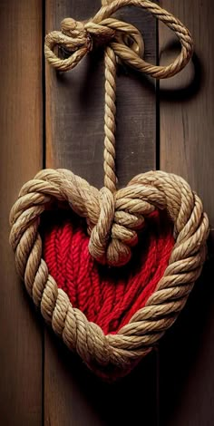 a heart shaped rope hanging on a wooden wall