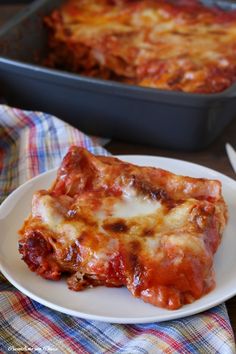 two slices of lasagna sitting on a plate next to a casserole dish