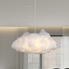 a large white cloud light hanging over a dining room table