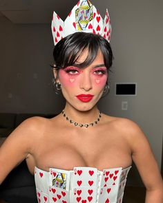 a woman with makeup on her face and wearing a costume made to look like queen of hearts