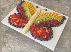 a butterfly shaped fruit platter on a table