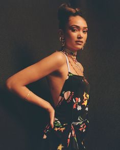 a woman in a floral dress posing for the camera with her hand on her hip