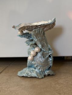 a blue sculpture sitting on top of a floor next to a wall