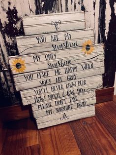 a stack of wooden signs sitting on top of a hard wood floor