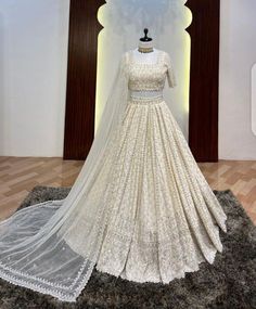 a white wedding gown on display in a room