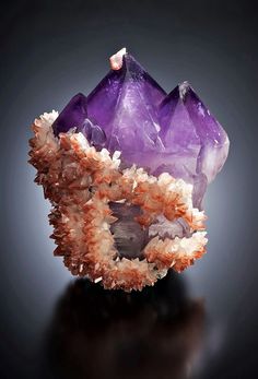 an amethorate with purple and white crystals on it's sides, against a black background