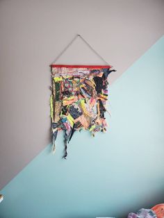 a wall hanging on the side of a blue and gray wall with various items in it