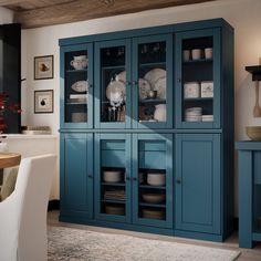 a blue china cabinet with glass doors in a dining room