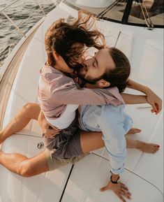 two people are hugging on the back of a boat