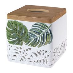 a white box with green leaves painted on the front and sides, along with a wooden lid