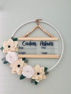 a wooden sign with flowers hanging from it's side and the words cadon aher above it