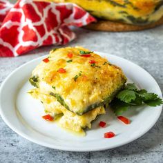 a white plate topped with an omelet covered in cheese and veggies