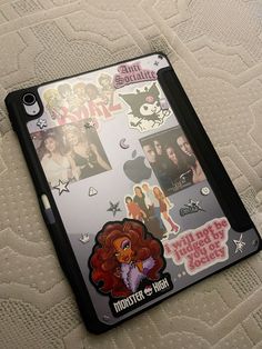 an ipad case with stickers on it sitting on top of a white bed sheet