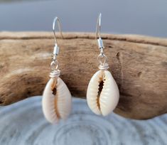 Puka shells, cowrie shell earrings, seashell jewelry, beach vacation earrings, holiday banquet party earrings, summer jewelry, handmade earrings, cute earrings, hypoallergenic earrings, lightweight everyday wear earrings. MATERIALS: ▪️Shell, high quality silver wire, hypoallergenic sterling silver hook earrings. ▪️All jewelry components are lead and nickel free. ▪️ Size: Length 1 inche. ▪️ Handmade items. These beautiful earrings are simple, beautiful for all things summer. They are the perfect gift for moms, friends, sister, daughter, or anyone who loves the ocean! These earrings are incredibly lightweight and super comfortable to everyday wear. SHELLS: The earrings are handcrafted in small batches and are made with authentic cowrie shells. Please understanding that natural shells are bea Cowrie Shell Dangle Earrings As Gift, Handmade Cowrie Shell Earrings For Gift, Handmade Cowrie Shell Earrings As Gift, Handmade Cowrie Shell Earrings For Beach, White Shell-shaped Cowrie Shell Earrings, White Cowrie Shell Earrings, Handmade Dangle Shell For Summer, Handmade Silver Shell For Beach, Handmade Shell Earrings Beachy Style