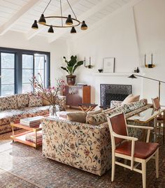 a living room filled with furniture and a fire place next to a large open window