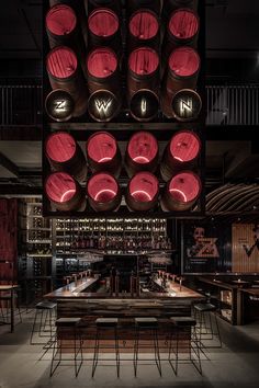 a bar with several wine barrels hanging from the ceiling and lights on it's sides