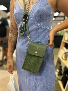 A multifunctional, stylish crossbody pouch perfect for on-the-go travel and events. Made with luxurious embossed vegan leather, designed in Hawaii, the Megan can hold even the largest phones and extra essentials. It features a dedicated phone pocket, as well as additional space for money or lip gloss. On the back, an extra pocket for ID or credit cards adds convenience. The detachable crossbody makes it versatile enough to fit into any bag, while still maintaining its sustainable island appeal. Add an Oceans End Luxe Strap for the ultimate statement. White Mules, Amusement Parks, Conscious Fashion, Clutch Pouch, Handbag Straps, Heels & Wedges, Extra Money, Credit Cards, Wedge Sandals