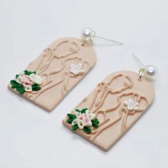 the earrings are decorated with flowers and pearls