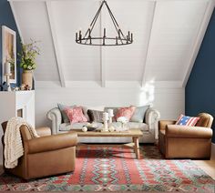 a living room filled with furniture and a chandelier hanging from the rafter