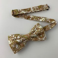 This handmade floral tie is an excellent accessory for weddings, parties, proms - an excellent gift for anyone who enjoys dressing-up dapper! Style: Slim/narrow Fabric: 100% cotton Approx. Measurements: (W) 2.4 in. x (L) 58 in. Dry clean only Matching Men's Bow Tie Style: Pre-tied (w/ adjustable straps) Fabric: 100% cotton Size: Mens | One size Bow measures approx. 4.75 in. x 2.4 in. Dry clean only Matching Pocket Square Fabric: 100% cotton Approx. 12 in. x 12 in. Dry clean only Thank you! Fitted Pre-tied Tie For Party, White Adjustable Bow For Wedding, Adjustable White Bow For Wedding, Adjustable White Suit And Tie Accessories For Groom, White Adjustable Suit And Tie Accessories For Wedding, Adjustable Satin Bow Tie For Wedding, Classic Pre-tied Ties For Wedding, White Bow Tie For Wedding, White Fitted Bow Tie For Parties