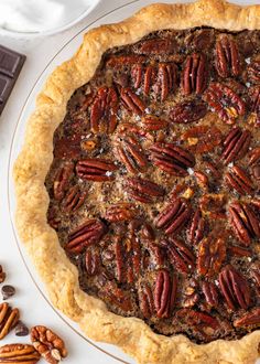 a pecan pie on a plate next to chocolate